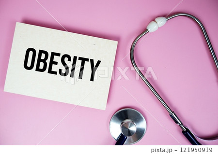 Obesity text with stethoscope on pink background, Healthy and wellness concept Obesity text with stethoscope on pink background, Healthy and wellness concept 121950919