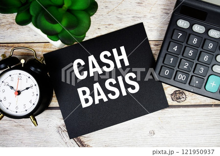 Cash Basis text with alarm clock and calculator on wooden background, Business concept 121950937