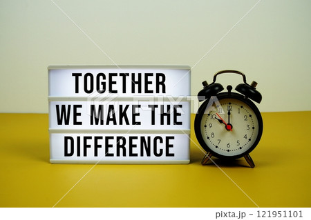 Together We Make The Difference text on light box with alarm clock on yellow background 121951101