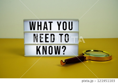 What You Need To Know? text on LED lightbox with magnifying glass on yellow background 121951103