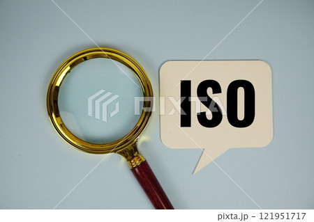 ISO text on speech bluble with magnifying glass top view on blue background ISO text on speech bluble with magnifying glass top view on blue background 121951717