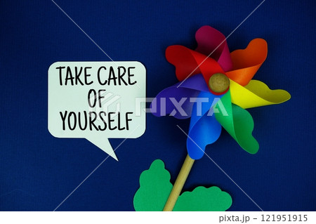 Take Care Of Yourself text motivational and inspiration quote with colorful pinwheel top view on blue background 121951915