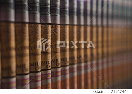 A detailed close up of cigars showcasing rich brown and gold bands. The alignment highlights the craftsmanship and luxury of the cigar collection. 121952449