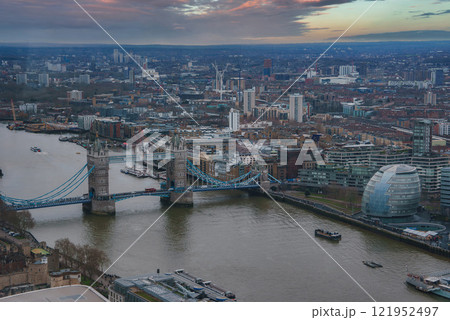 The image captures Tower Bridge over the River Thames with City Hall nearby. Boats navigate the river, surrounded by historic and modern architecture. 121952497