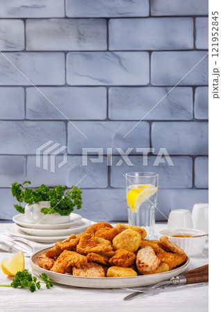 fried chunks, bites, tenders, nuggets on a plate fried chunks, bites, tenders, nuggets on a plate 121952845