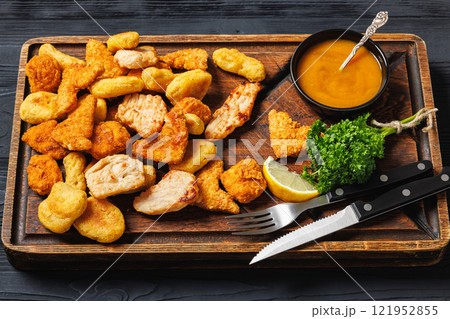 fried chunks, bites, tenders, nuggets on a plate 121952855