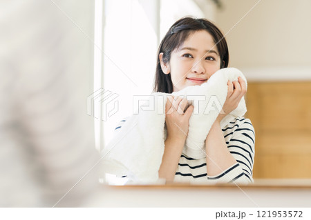 洗面所で顔を洗う女性 121953572