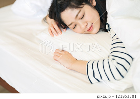 ベッドにうつ伏せで寝る女性 ベッドにうつ伏せで寝る女性 121953581