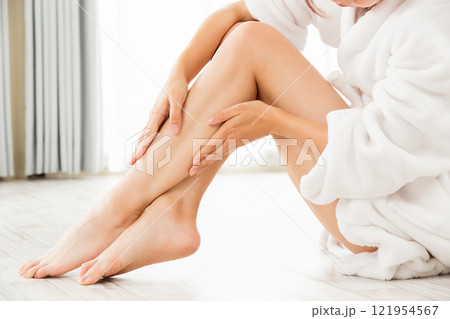若いアジア人の女性は脚のスキンケアをしている。 若いアジア人の女性は脚のスキンケアをしている。 121954567