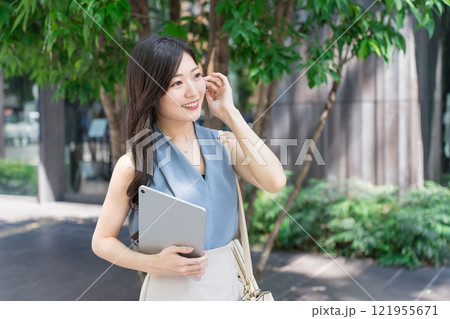 オフィス街でタブレット端末を持つビジネスウーマン 121955671