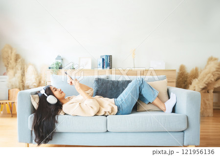 High angle view of happy cheerful positive young Asian woman on the phone at home 121956136
