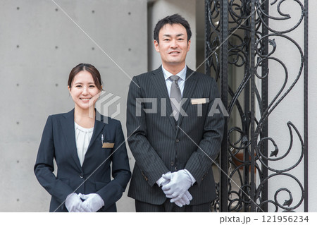 ホテルで働くスーツ姿のコンシェルジュ・ホテルマン・ホテリエ・ウェディングプランナーの男女ホテルで働く 121956234