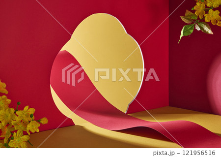 A minimalist image with traditional New Year for product advertising. A red paper scroll that is winding and creates an empty space for product presentation, accented with yellow apricot blossoms. 121956516