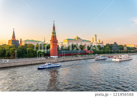 View of Kremlin with Vodovzvodnaya tower, Grand Kremlin Palace from repaired Bolshoy Kamenny Bridge in Moscow city on sunny summer day. Cruise ship sails on the Moscow river 121956588