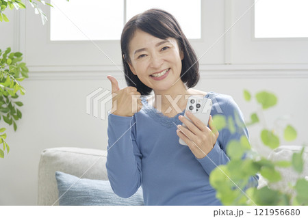 スマホを持つ中年女性 グッドポーズ リビング スマホを持つ中年女性 グッドポーズ リビング 121956680