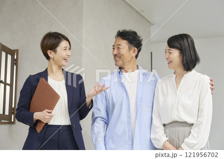 不動産屋と話す夫婦 121956702