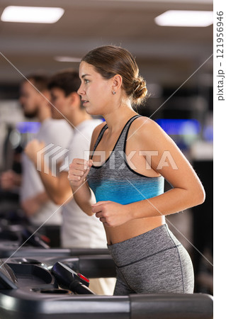 Focused girl works out with treadmill during class at fitness club Focused girl works out with treadmill during class at fitness club 121956946