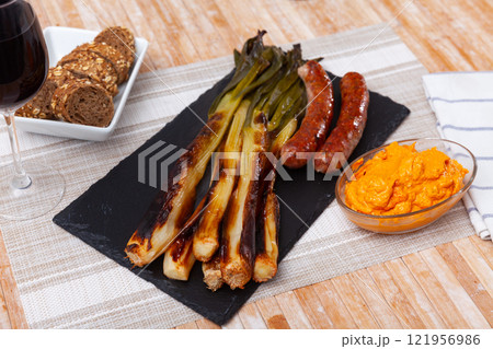 Top view of Catalan grilled calsot with sausage. Calsot con butifarra Top view of Catalan grilled calsot with sausage. Calsot con butifarra 121956986