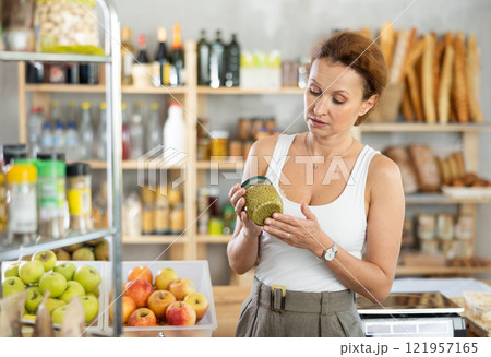 Adult woman choosing green peas in grocery store Adult woman choosing green peas in grocery store 121957165