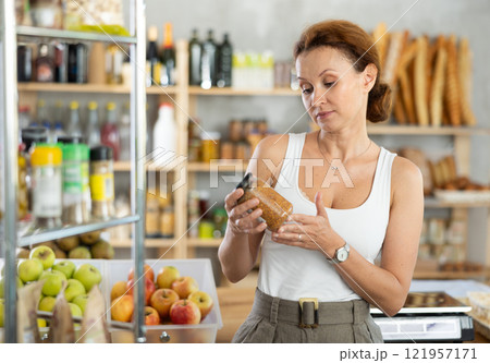 Adult woman choosing lentils in grocery store Adult woman choosing lentils in grocery store 121957171