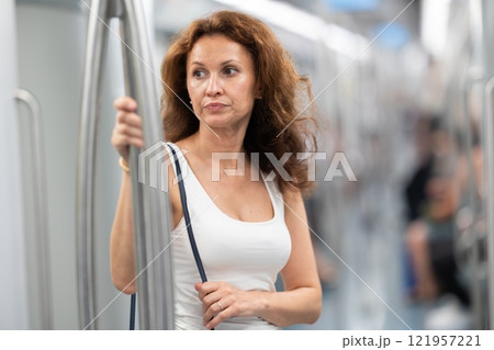 Portrait of woman passenger standing inside train at metro wagon Portrait of woman passenger standing inside train at metro wagon 121957221