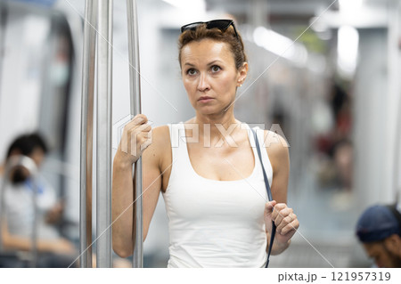 Adult woman stands in subway car 121957319