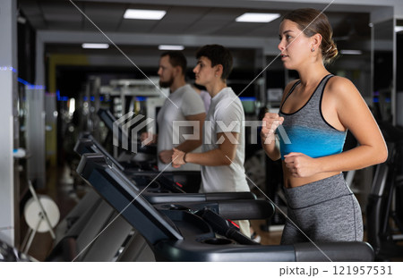 Focused girl works out with treadmill during class at fitness club Focused girl works out with treadmill during class at fitness club 121957531