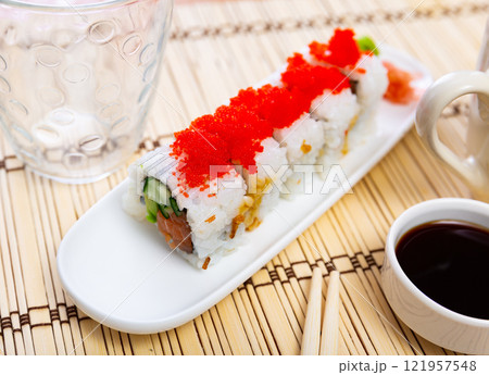 Uramaki Tobiko roll with salmon, cucumber, avocado wrapped in rice with tobiko caviar. Uramaki Tobiko roll with salmon, cucumber, avocado wrapped in rice with tobiko caviar. 121957548