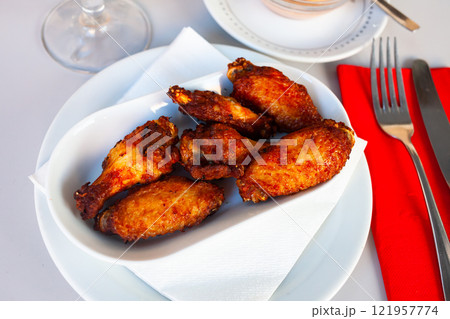Tasty crispy grilled chicken wings on plate 121957774