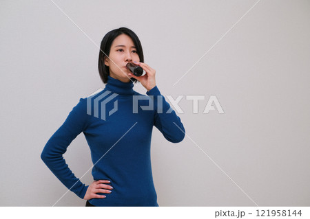 栄養ドリンクを飲む女性のクローズアップ 121958144