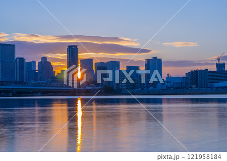 淀川を挟んで見る大阪梅田の高層ビル群と日の出 121958184