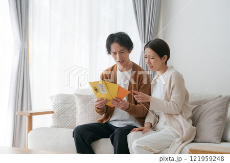 督促状の封筒を見る夫婦 121959248