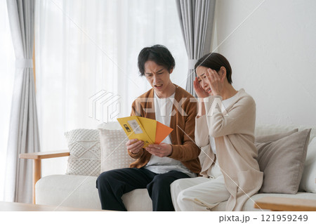 督促状の封筒を見る夫婦 121959249