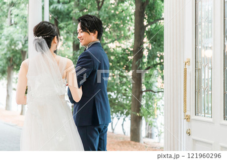 結婚式場を歩く新郎新婦の後ろ姿(入場・結婚式・アジア人) 結婚式場を歩く新郎新婦の後ろ姿(入場・結婚式・アジア人) 121960296