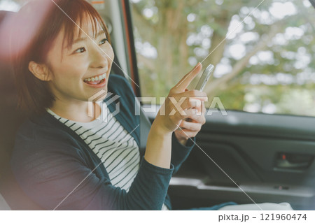 スマホ地図アプリでルート検索する助手席の女性 スマホ地図アプリでルート検索する助手席の女性 121960474