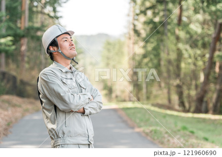 公園・森林で樹木をチェックする作業着姿の林業の男性 公園・森林で樹木をチェックする作業着姿の林業の男性 121960690