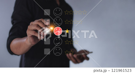 Young man with smartphone mobile hand hold a pen touching to review and gives 1 star Young man with smartphone mobile hand hold a pen touching to review and gives 1 star 121961523