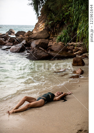 Enjoying a Relaxing Beach Moment A Serene Pose on the Warm Sandy Shore with Beauty Enjoying a Relaxing Beach Moment A Serene Pose on the Warm Sandy Shore with Beauty 121961644