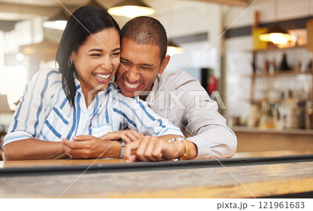 Couple laughing at funny joke at restaurant, boyfriend and girlfriend bonding with smile on romantic date and celebrating anniversary at coffee shop. Husband and wife showing love, having fun at cafe 121961683