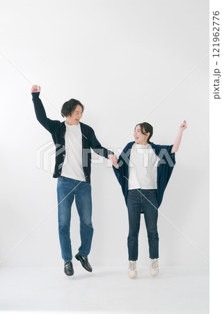 手をつないでジャンプをするカップル 121962776