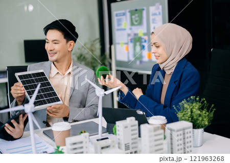 Group of diverse multiethnic businesspeople standing neare table looking at model of building from residential project. 121963268