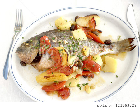 Dorada baked with vegetables on white plate. Isolated photo on white background for design. Food and natural seafood.  121963328