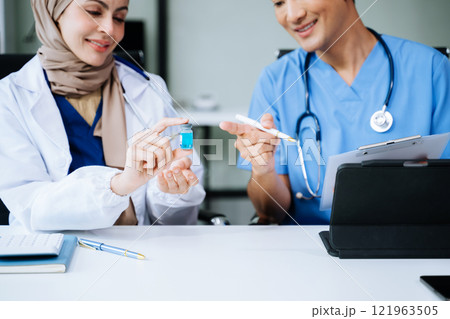 Doctor Talks With Professional Head Nurse or Surgeon, They Use Digital tablet Computer. Diverse Team of Health Care Specialists Discussing Test Result on desk Doctor Talks With Professional Head Nurse or Surgeon, They Use Digital tablet Computer. Diverse Team of Health Care Specialists Discussing Test Result on desk 121963505
