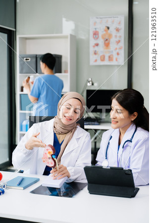 Doctors analyzing results or diagnosis of patient in clinic. Teamwork, medical and healthcare workers in discussion and research on desk in hospital Doctors analyzing results or diagnosis of patient in clinic. Teamwork, medical and healthcare workers in discussion and research on desk in hospital 121963510