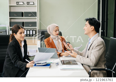 Asian businesspeople while collaborating on a new project.  using a laptop and tablet 121963761