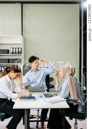 Furious two Asian businesspeople arguing strongly after making a mistake at work Furious two Asian businesspeople arguing strongly after making a mistake at work 121963966