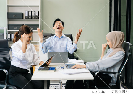 Happy businesspeople while collaborating on a new project in an office. Happy businesspeople while collaborating on a new project in an office. 121963972