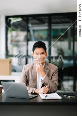 Businessman working at office with laptop, tablet and taking notes on the paper. 121964899