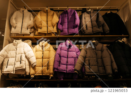 winter jackets on the store shelf. warm clothes on sale in the showroom 121965053