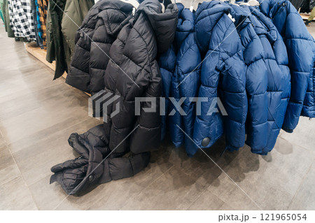 winter jackets on the store shelf. warm clothes on sale in the showroom 121965054